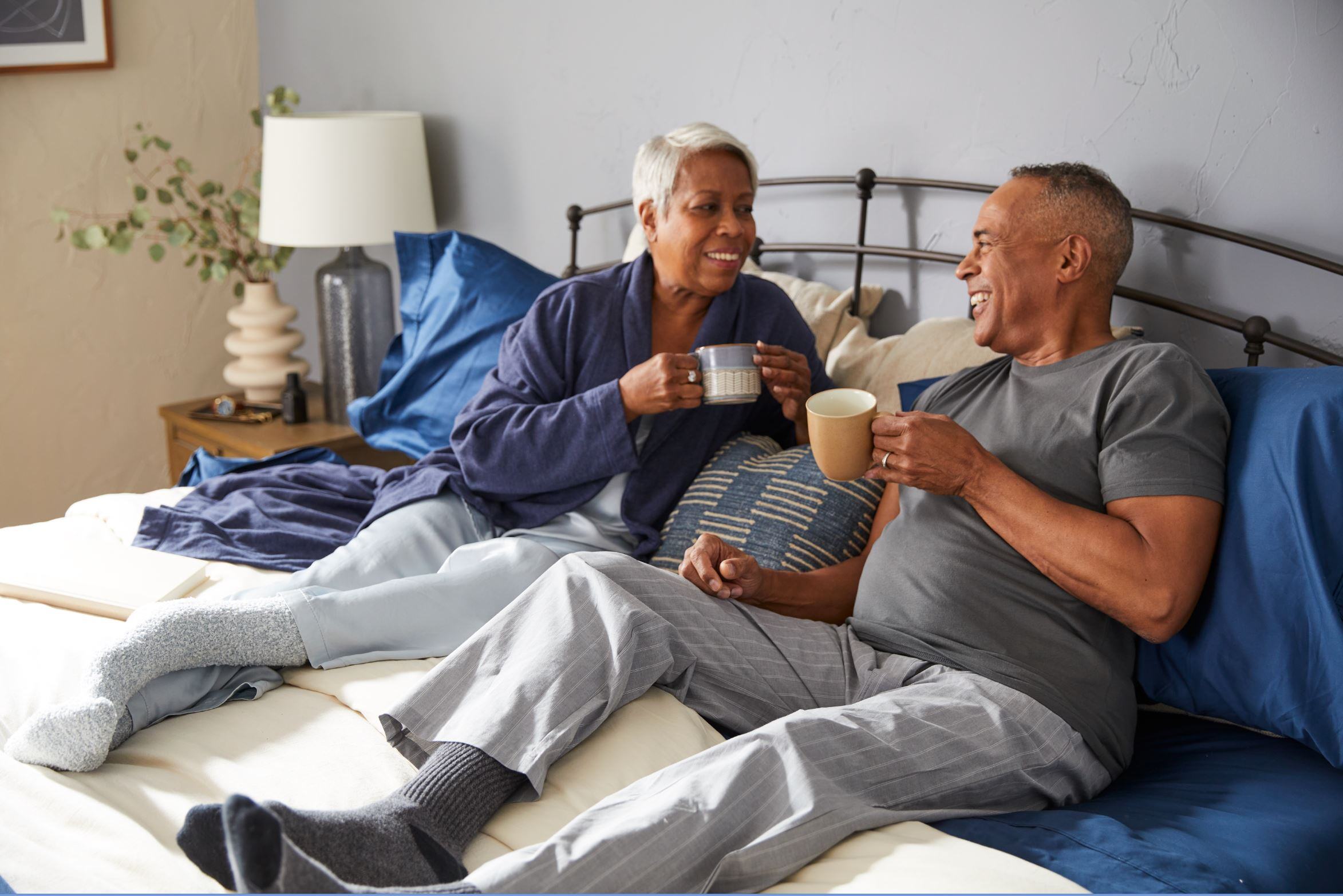 older couple enjoying coffee on a comfortable mattress 